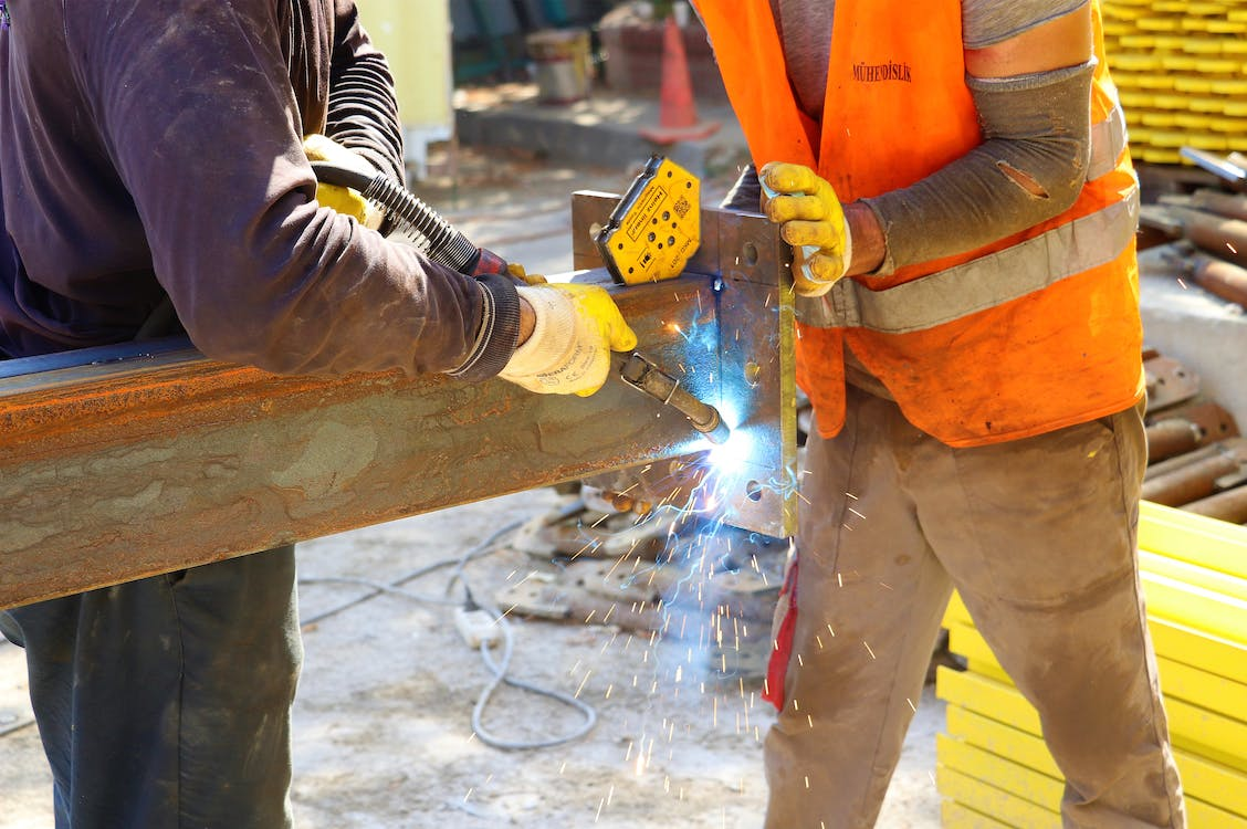 Construction workers wearing PPE while welding metal