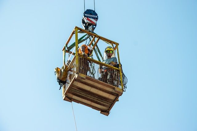 Two construction workers In an aerial lift.