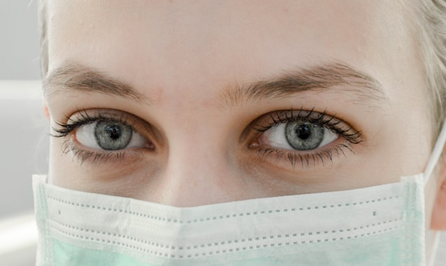 A close-up of a health worker wearing a protective mask.